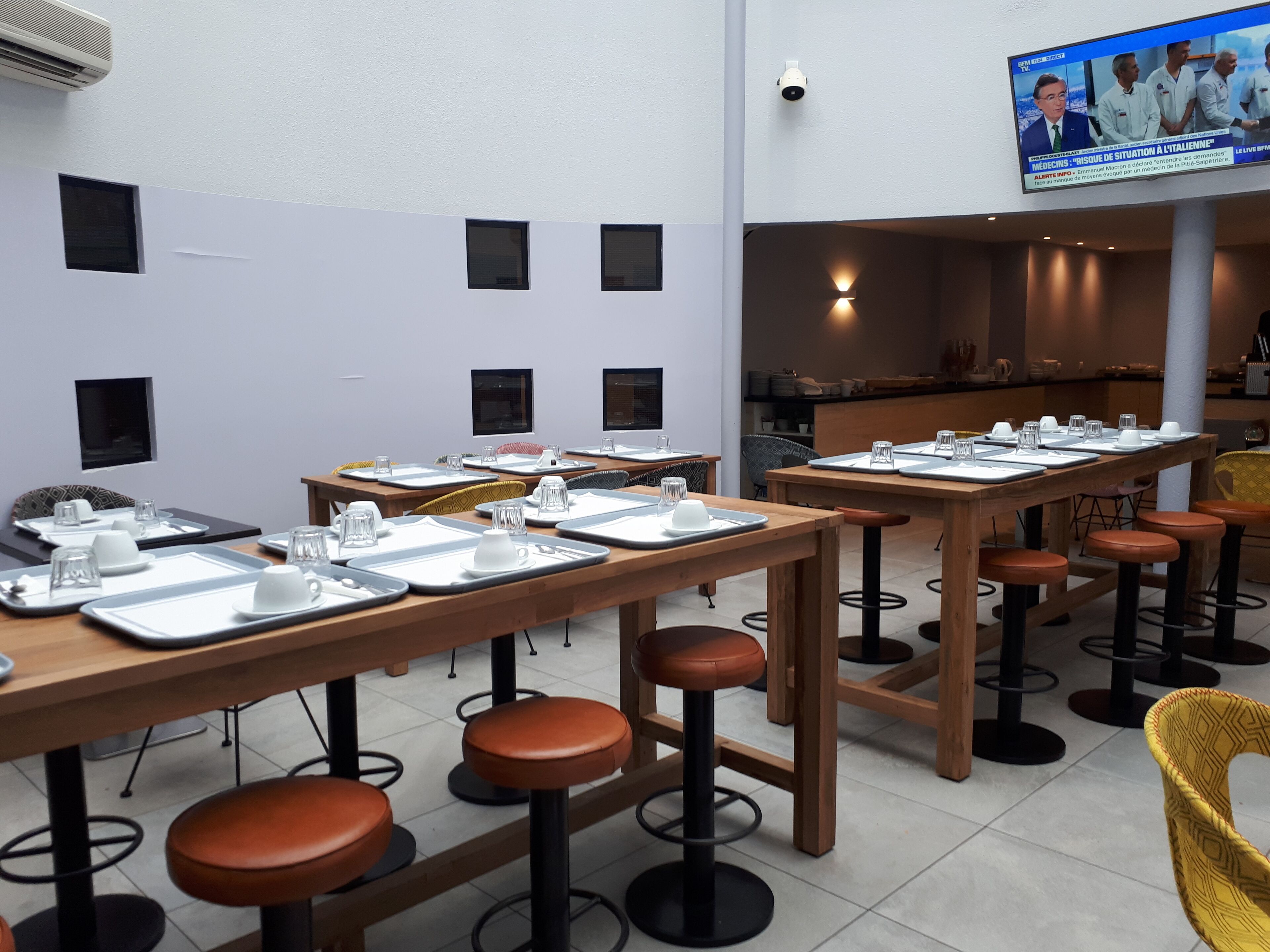 A modern conference room with multiple tables set for meetings, equipped with nameplates, water glasses, and notepads.