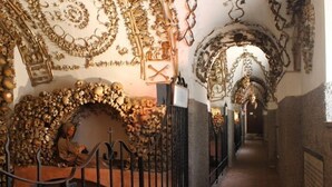 A corridor with ornate wall decorations, a staircase with a person sitting, and a metal railing. - Hotel Garda (Rome)