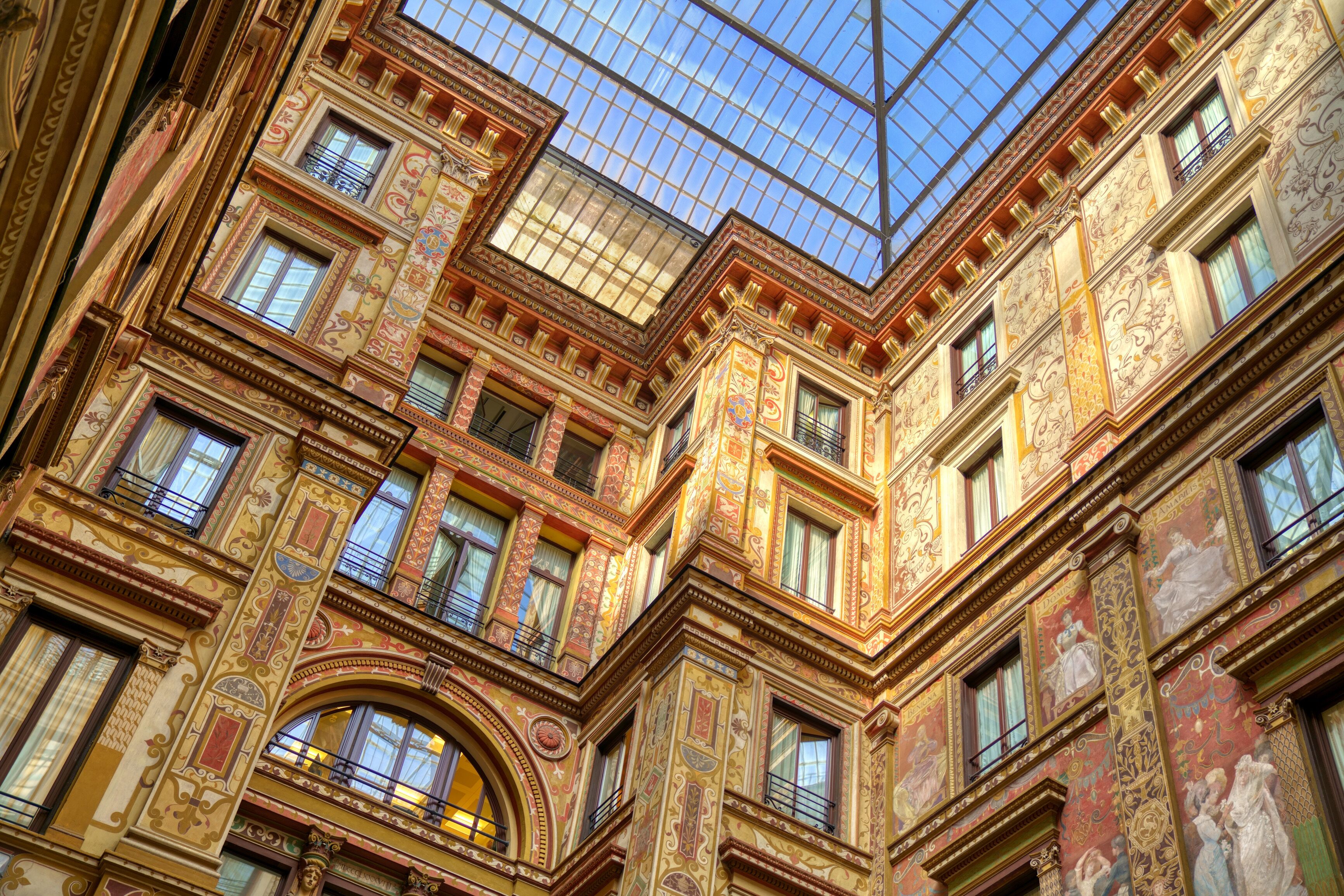 Un immeuble à plusieurs étages, doté de détails architecturaux raffinés, de grandes fenêtres et d’un plafond en verre.