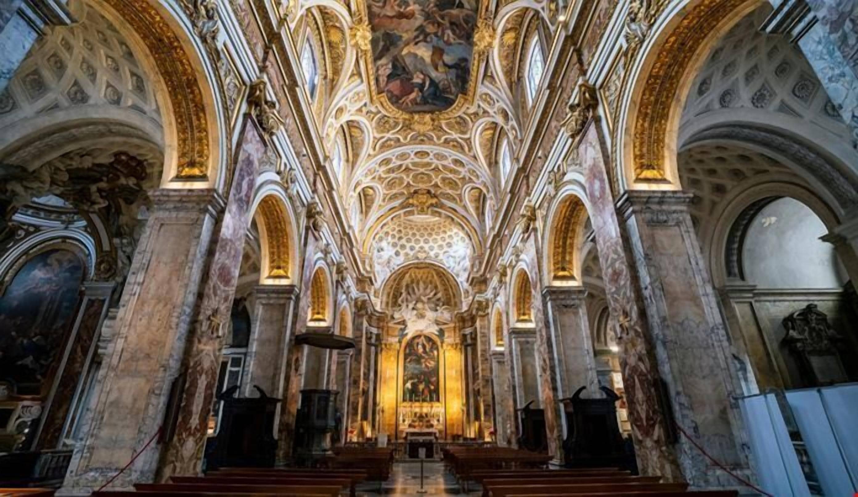 Et interieur fra en katedral med hvælvede lofter, udsmykkede søjler og et centralt alter.