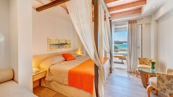 Un dormitorio con cama, mesita de noche y vista al mar.