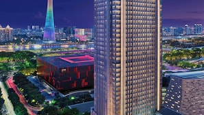 A high-rise hotel with a modern design, featuring a prominent entrance and a rooftop pool area. - The Ritz-Carlton, Guangzhou (Guangzhou)