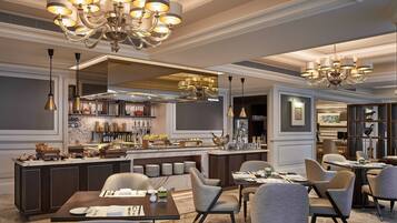 Un restaurante moderno con barra central, varias zonas de estar y elegantes candelabros.