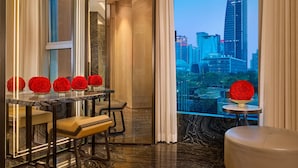 A modern hotel room with a city view, a glass table with red spherical decorations, and a bench. - The Ritz-Carlton, Guangzhou (Guangzhou)