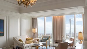 A hotel room with a large window, a sofa, a chair, a small table, and a lamp. - The Ritz-Carlton, Guangzhou (Guangzhou)
