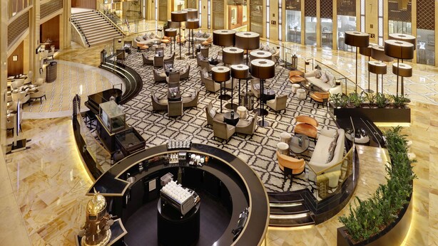 A spacious lobby with a central seating area, a staircase, and a reception desk. - The H Dubai (Dubai)