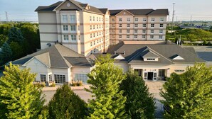 A multi-story hotel with a central courtyard, large windows, and a parking area. - Homewood Suites by Hilton Toronto-Markham (Markham)