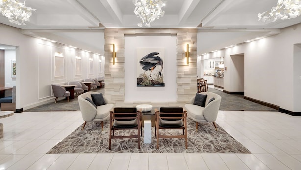 A spacious lobby with a central seating area, a large abstract painting, and a modern chandelier. - Homewood Suites by Hilton Toronto-Markham (Markham)