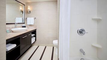 A modern bathroom with a sink, mirror, towel rack, and a shower area.