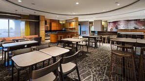 A modern hotel lobby with multiple seating areas, a central bar, and a view of the outside. - SpringHill Suites by Marriott Denver Airport (Denver)