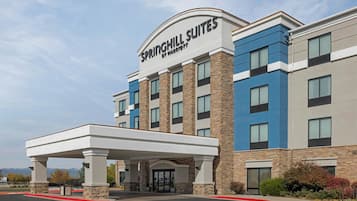 Een hotel met een overdekte ingang, meerdere verdiepingen en een opvallend bord met Springhill Suites by Marriott.