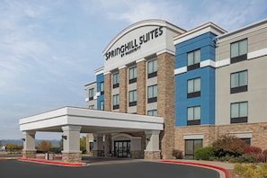 Um hotel com entrada coberta, vários andares e uma placa bem visível da Springhill Suites by Marriott.