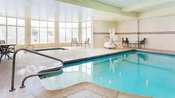 Una piscina techada, sillones reclinables de piscina
