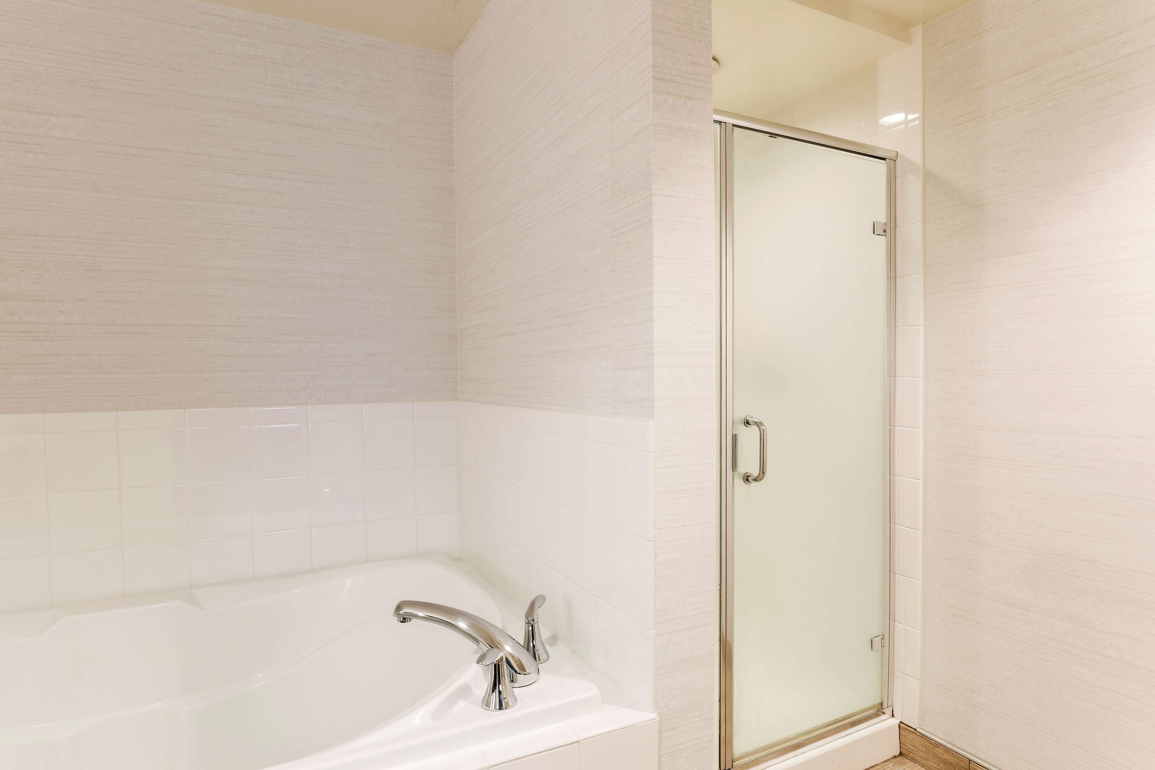 Une salle de bain avec une baignoire blanche et une douche à l’italienne.