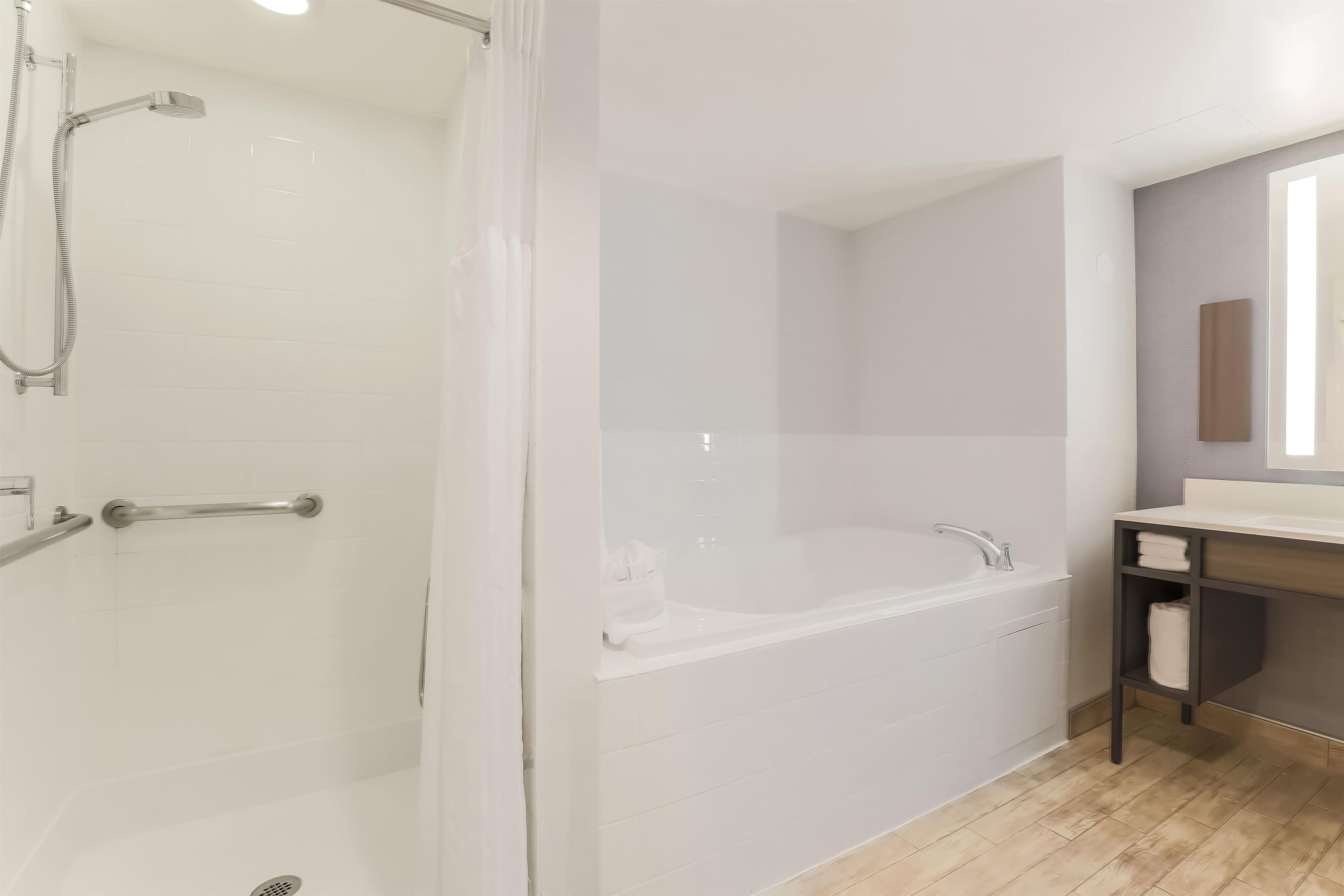 Une salle de bain moderne équipée d’une douche, d’une baignoire et d’un meuble-lavabo avec un miroir.