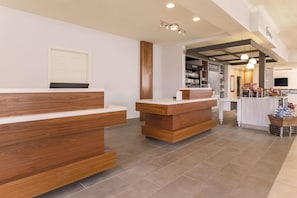 A reception area with wooden counters and a tiled floor.