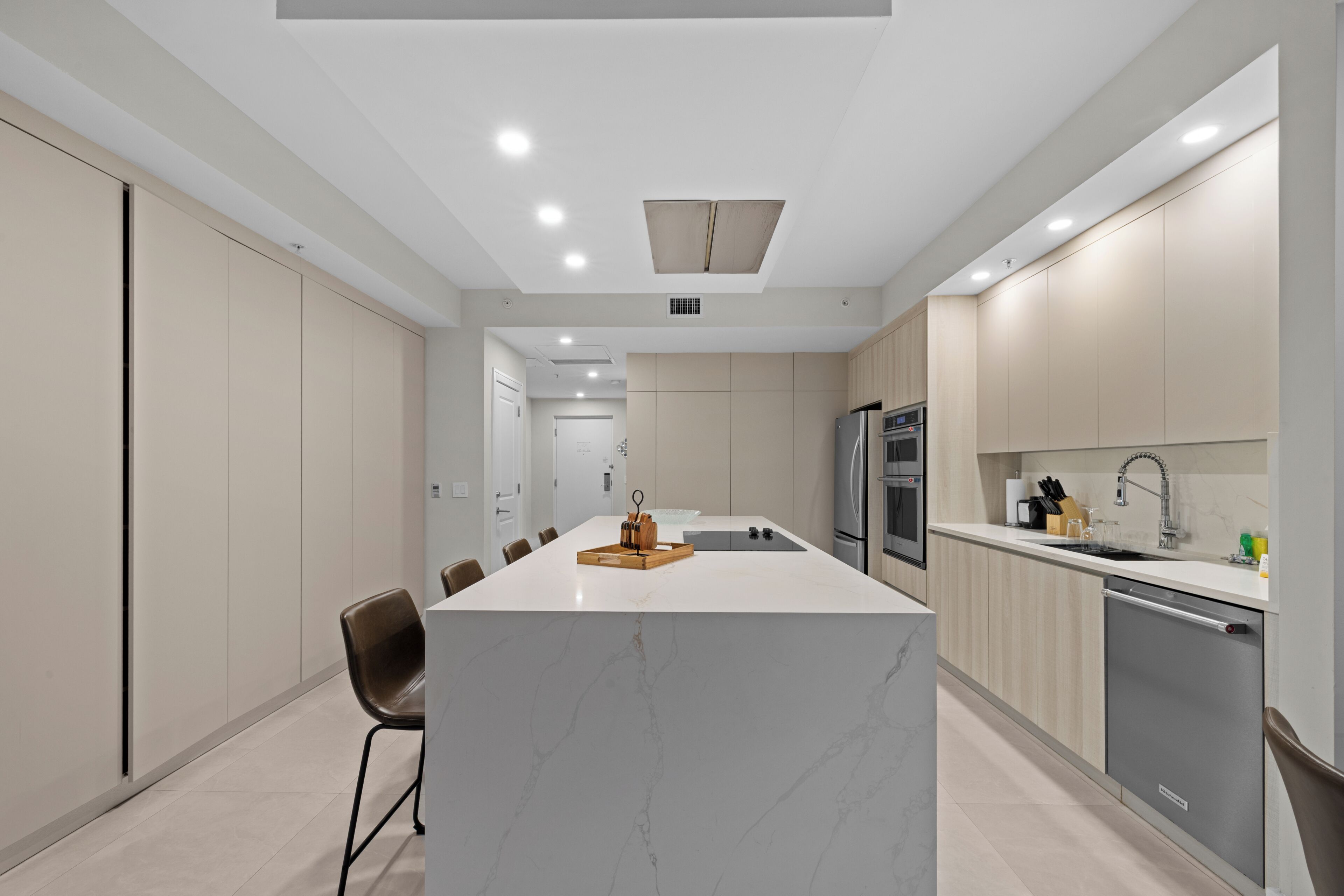 A modern kitchen with a central island, built-in appliances, and a minimalist design.
