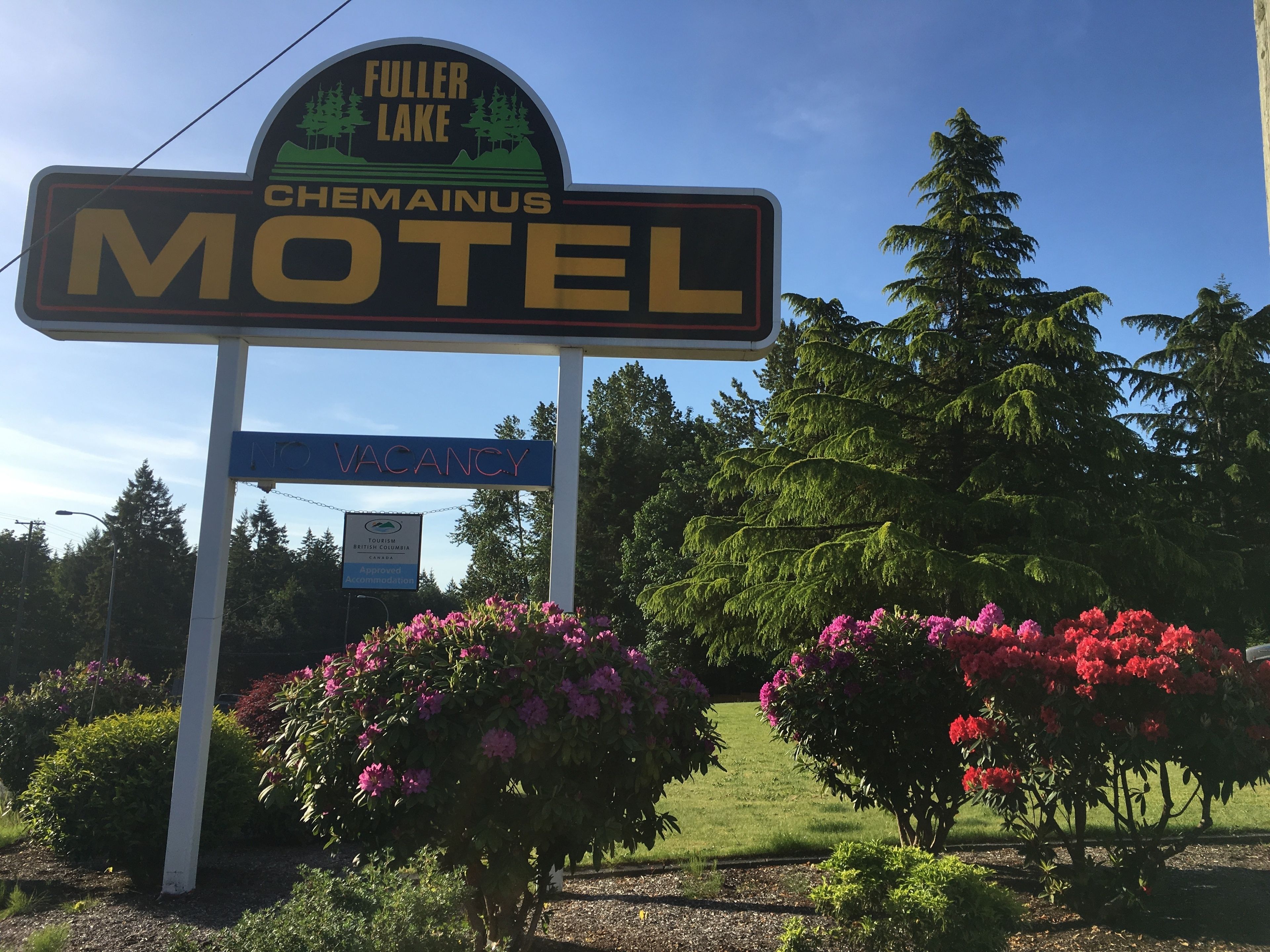 Letrero de motel que dice 'FULLER LAKE CHEMAINUS MOTEL' y un letrero que indica 'NO DISPONIBLE' debajo.