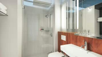 A modern bathroom with a glass-enclosed shower, a wooden vanity, and a large mirror.