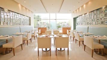 A spacious restaurant with high ceilings, large windows, and a modern interior design.