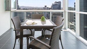 Un balcon avec une table et des chaises, offrant une vue sur la ville.