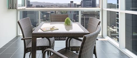 Un balcon avec une table et des chaises, offrant une vue sur la ville.