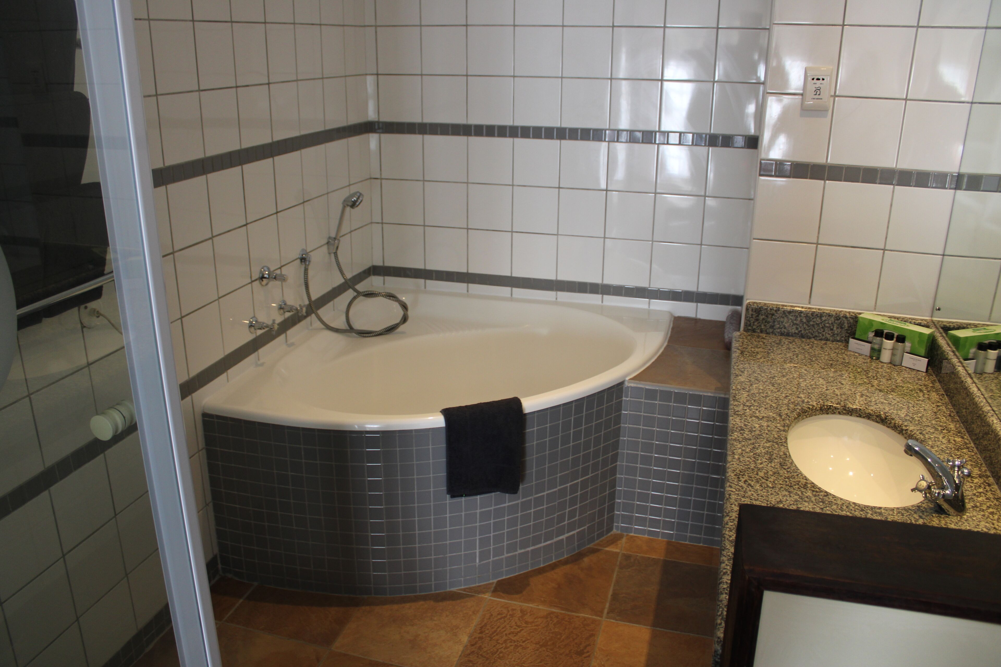 A bathroom with a bathtub, a sink, and tiled walls.