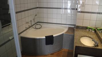 A bathroom with a bathtub, a sink, and tiled walls.
