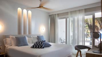 A modern hotel room with a large bed, a desk, and a ceiling fan.