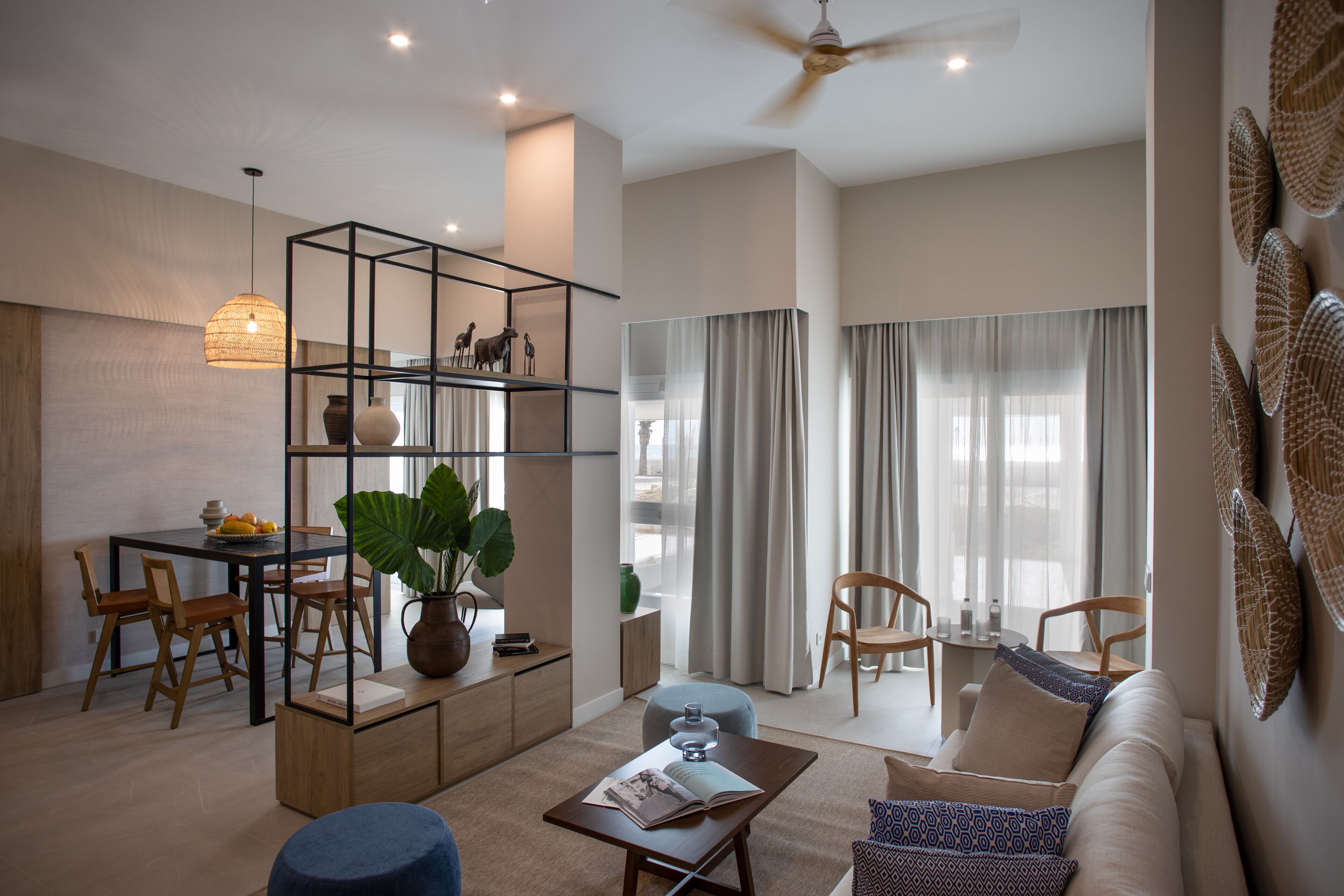 A modern living room with a sofa, coffee table, and dining area.