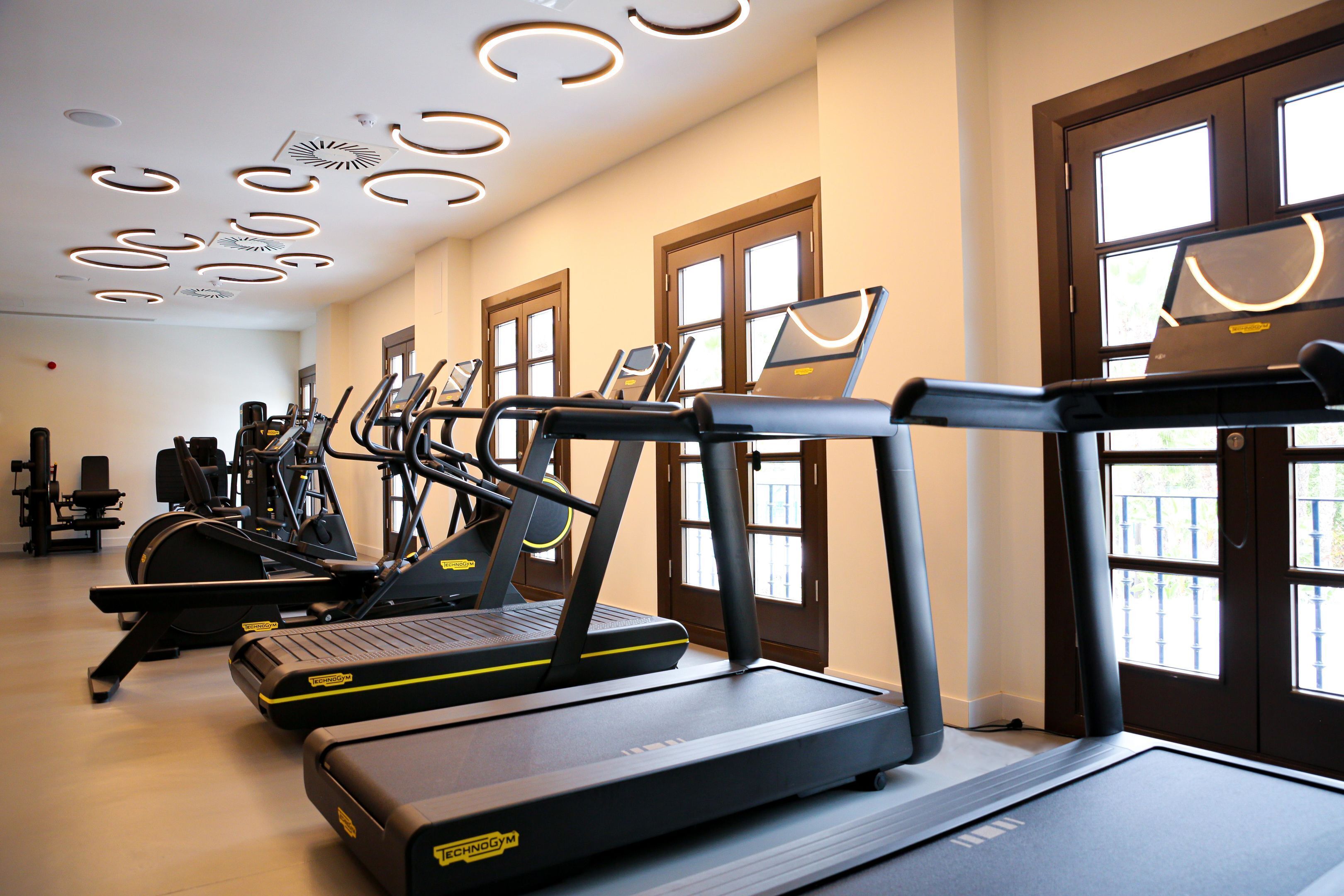 A gym with multiple treadmills, exercise bikes, and a variety of other fitness equipment.