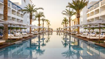Una piscina al aire libre, cabañas de piscina (de pago), sombrillas