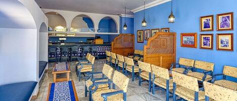 A restaurant with blue walls, wooden furniture, and framed pictures on the walls.