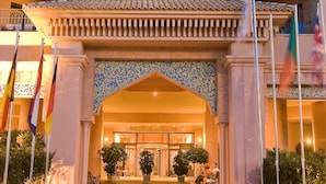 A hotel entrance with a tiled facade, multiple balconies, and a central archway. - Playacanela Hotel (Ayamonte)