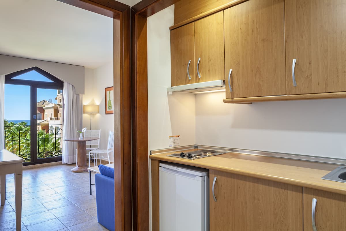 Une cuisine compacte avec des meubles de rangement en bois, un lave-vaisselle encastré et un petit plan de travail.