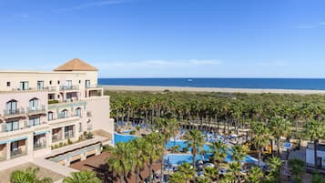 Relax by the pool surrounded by lush palm trees and enjoy stunning beach views.
