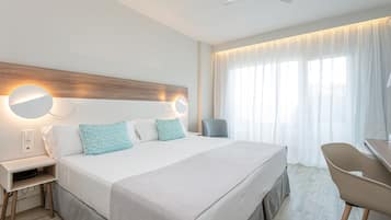 Una habitación de hotel moderna con una cama grande, mesitas de noche, un escritorio y una silla.