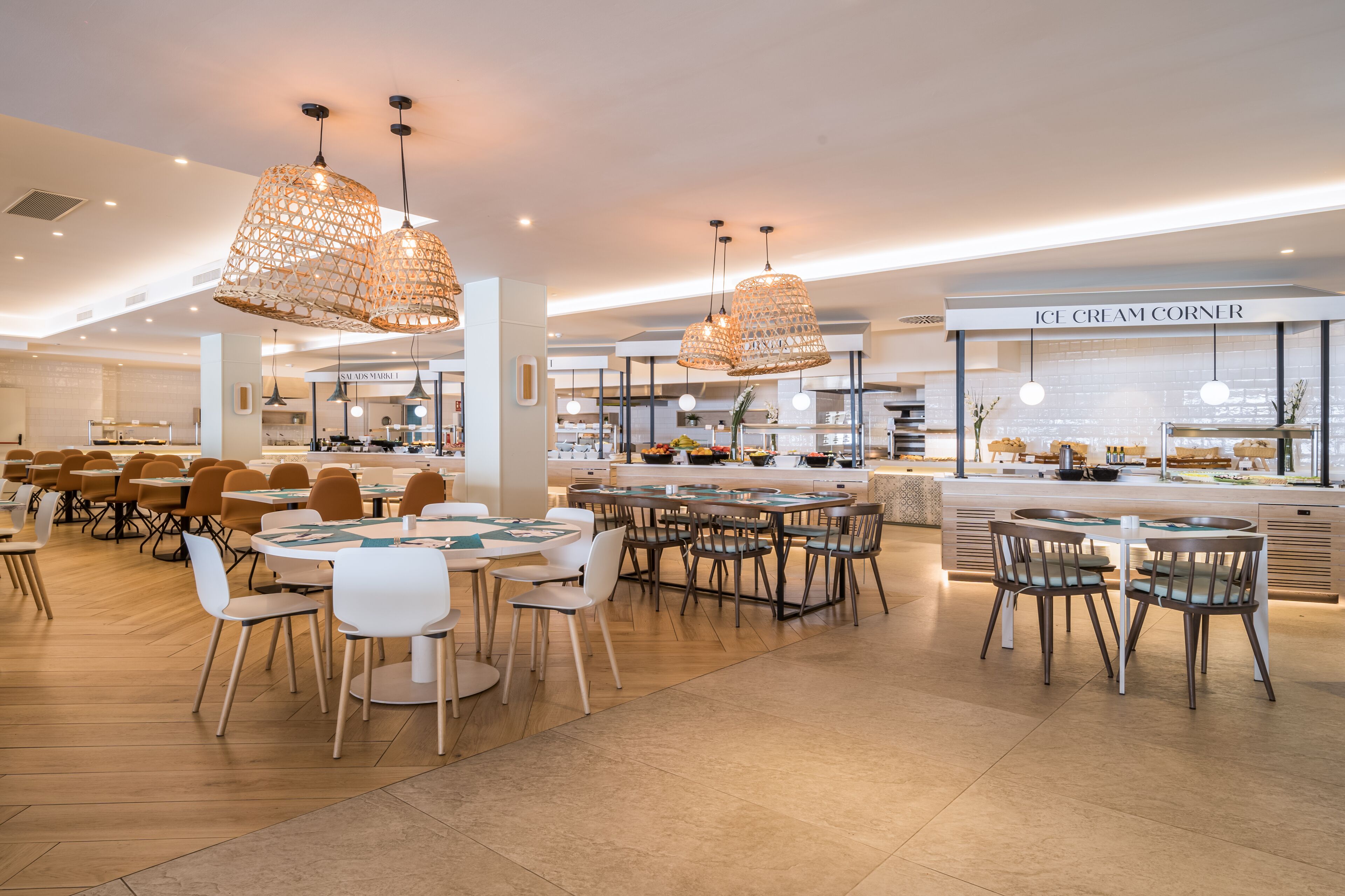 A modern restaurant with multiple dining areas, including a bar and a counter with a sign reading "ICE CREAM CORNER".