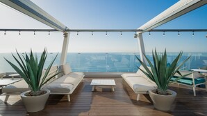 A deck with two sofas, a coffee table, and two potted agave plants.