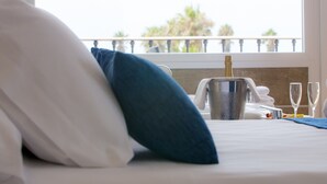 A hotel room with a bed, a bucket of champagne, and two glasses on the nightstand. - Playaballena Hotel (Rota)