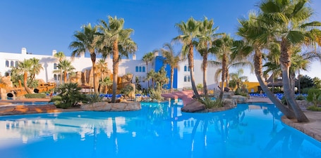 Una piscina al aire libre, sombrillas, sillones reclinables de piscina. Playaballena Hotel