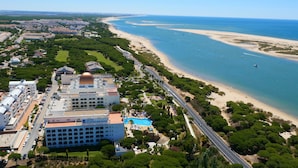 Un hotel frente al mar con piscina, acceso a la playa y vistas al océano.