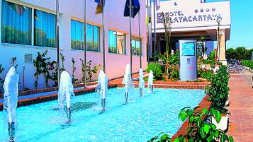 Un hotel con piscina, varias banderas y un letrero que dice "HOTEL MAYACARTAVA".