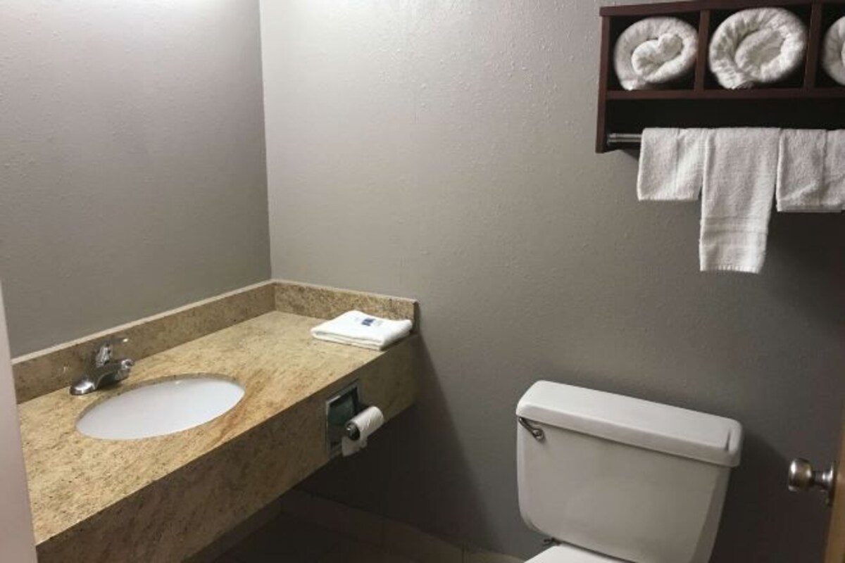 Et badeværelse med håndvask, toilet og håndklædestang.