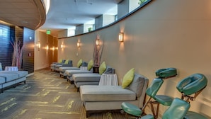 A modern spa area with multiple massage chairs, a curved ceiling, and ambient lighting.