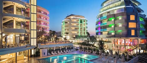 A hotel with a swimming pool, multiple balconies, and modern architecture.