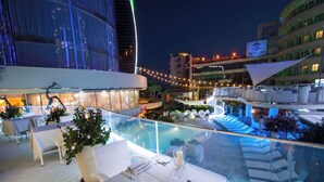 A rooftop pool area with seating and tables, surrounded by greenery and modern buildings. - Hotel Waldorf - Premier Resort (Cervia)