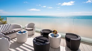A balcony with wicker furniture, a small table with fruit, and a view of the sea. - Hotel Waldorf - Premier Resort (Cervia)