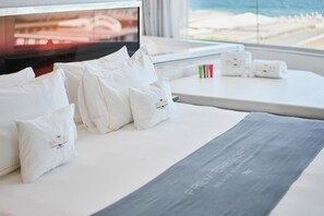 Una habitación de hotel con una cama, almohadas, una manta y un televisor.