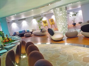 Un moderno espacio de sala de estar con arreglos de asientos, una recepción y detalles decorativos.